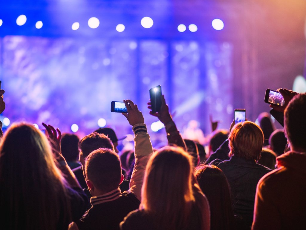 People filming a music concert.