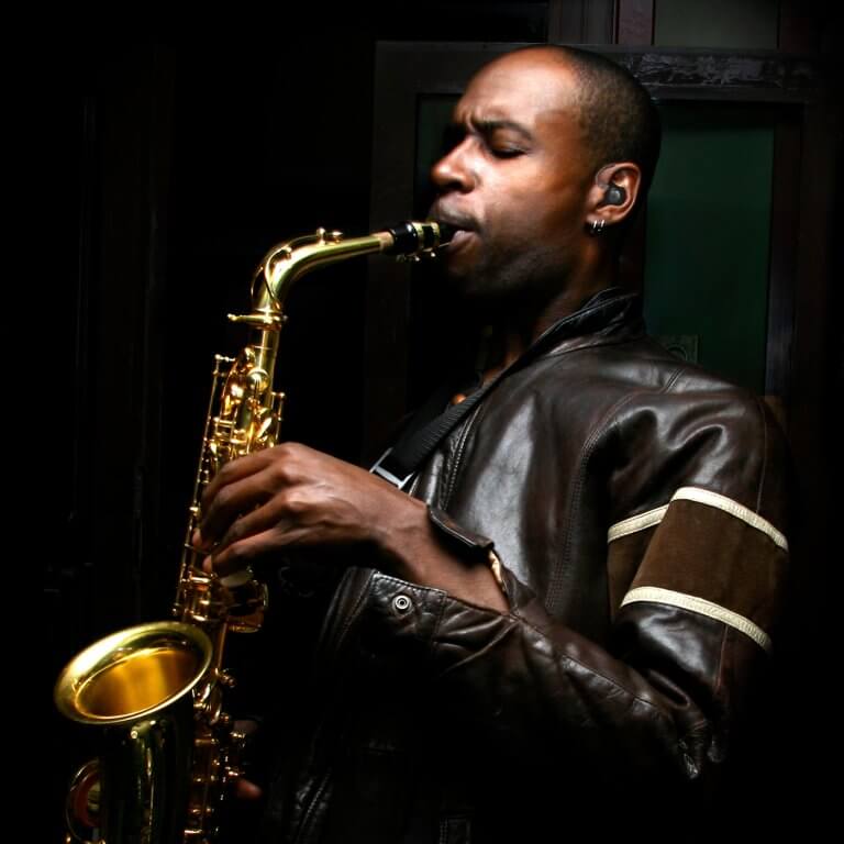 A man playing saxophone with hearing protection.