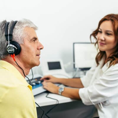 An audiologist performing a hearing test on a patient.