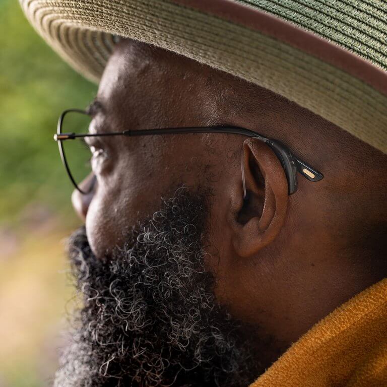 A man wearing a hearing aid and glasses.