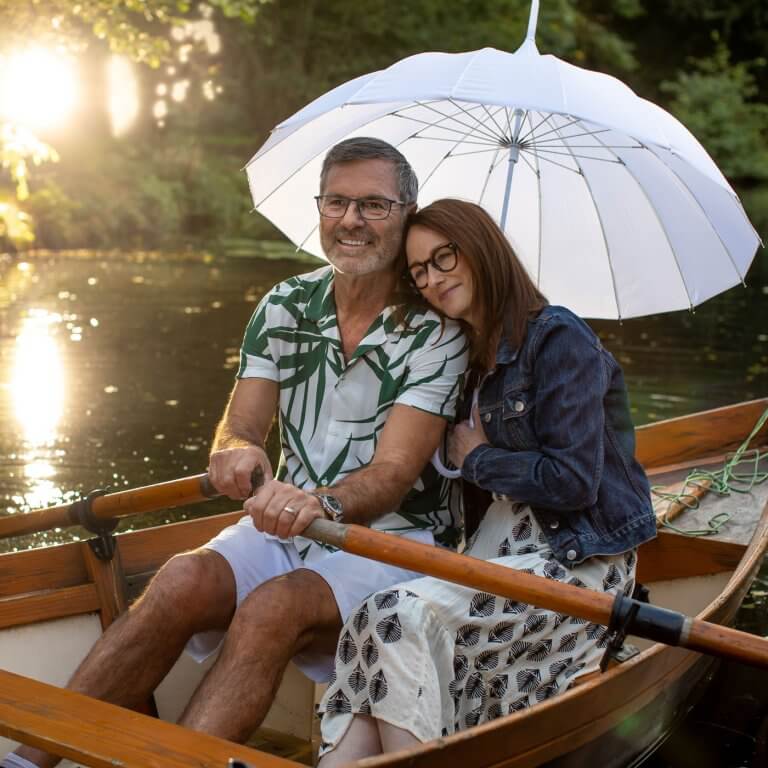 A happy couple in rowing boat with glasses.