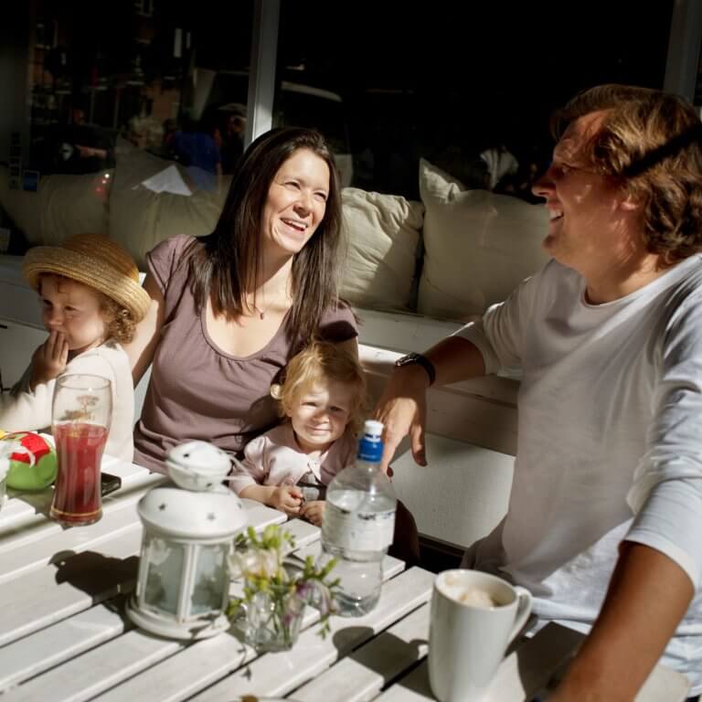 A family around garden seats drinking tea.