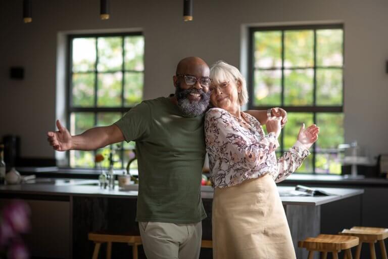 Two people dancing in a kitchen.