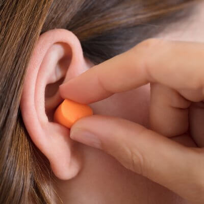 A woman putting on ear protection.
