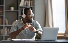 Aman at a desk with headphones on.