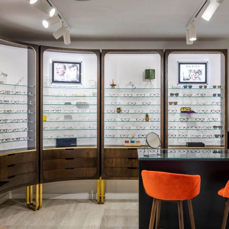 Multiple eyeglass displays arranged inside an optician's shop.