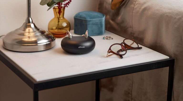 oticon-opn-s-hearing-aid-on-bedside-table-charging