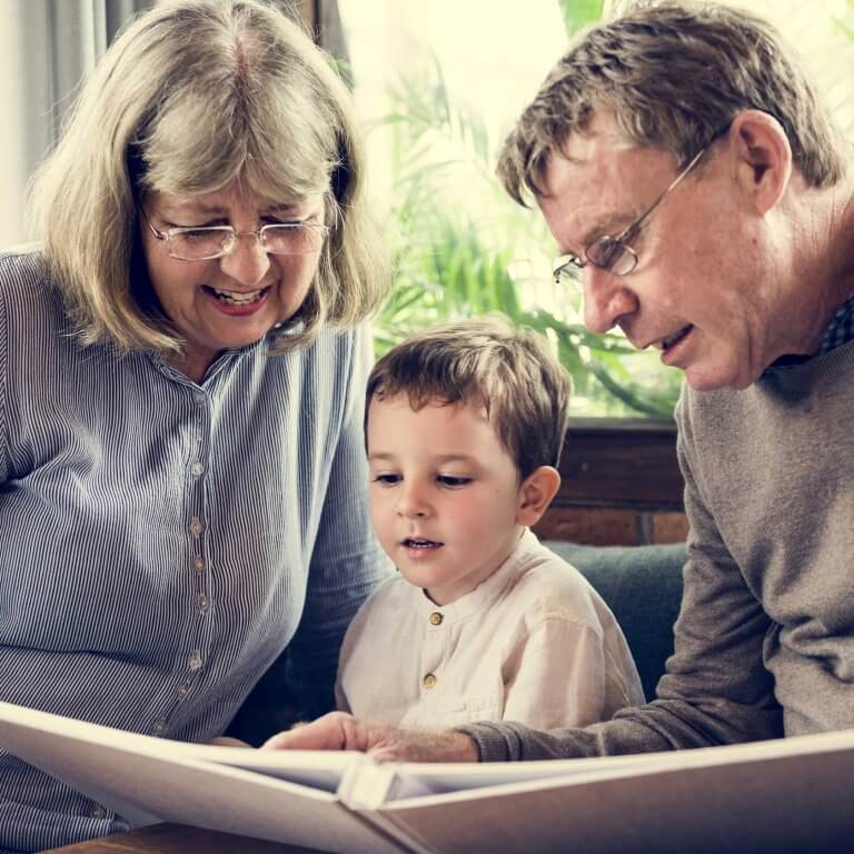 Grandparents reading a story to their grandson.