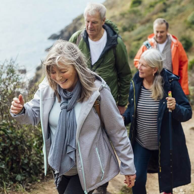 Elderly people hiking next to the sea.