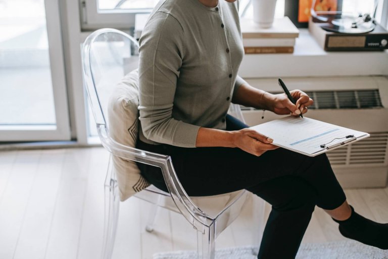 A woman writing on a clipboard.