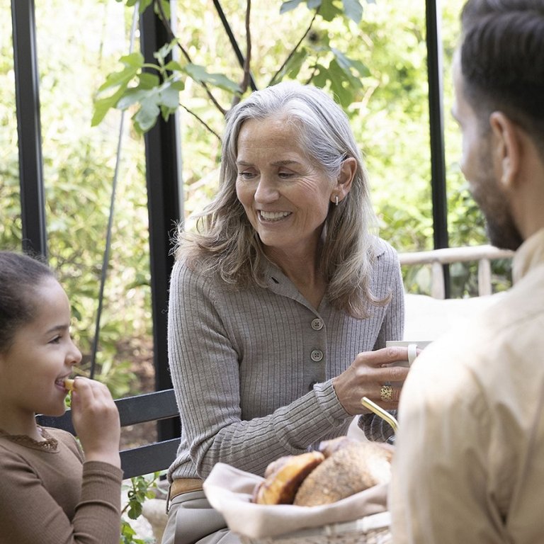 A family having tea and eating in the patio.