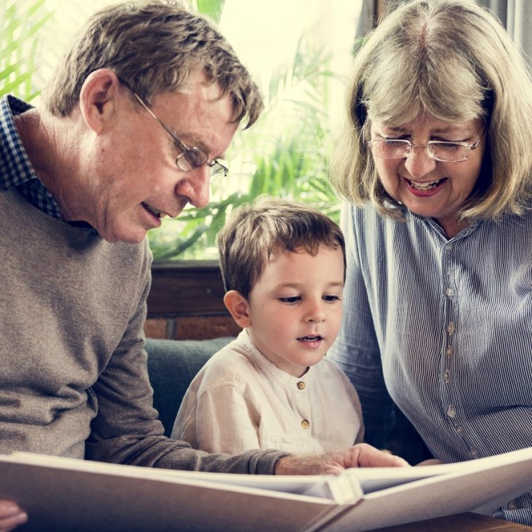 Grandparents reading a story to their grandson.