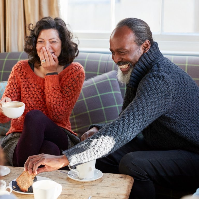 A couple laughing and having breakfast.