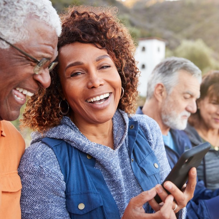 A couple on their phones and laughing.