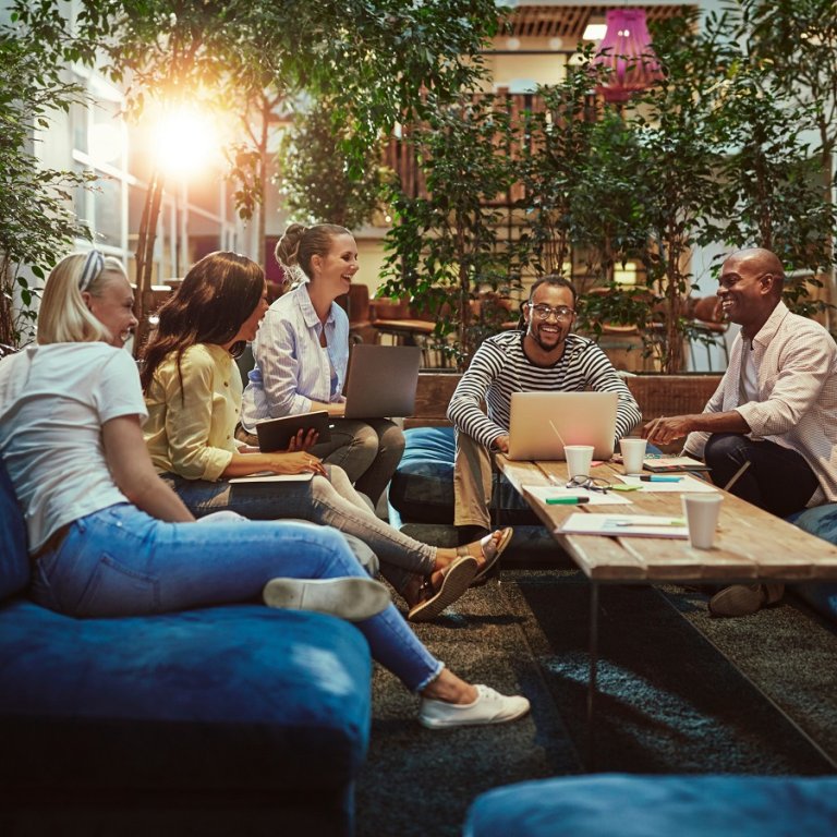 A group of young people working around a table and laughing.