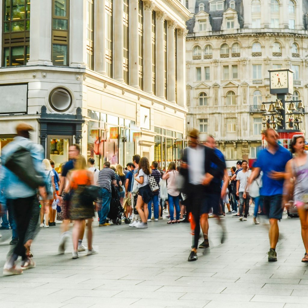 A bustling city street filled with pedestrians walking in various directions.