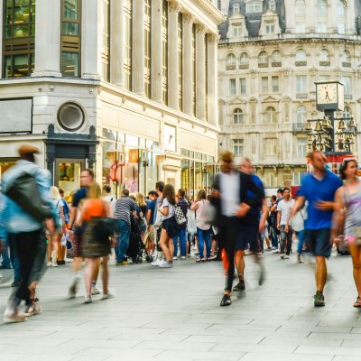 A bustling city street filled with pedestrians walking in various directions.