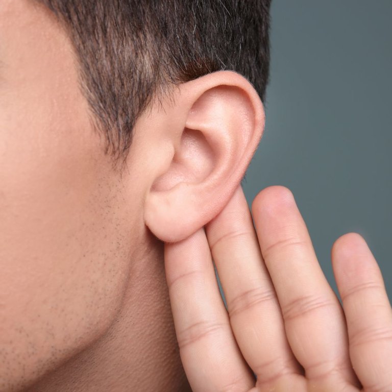 A man holding his ear to listen.