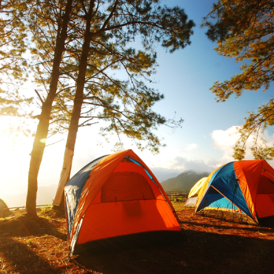 Tents at a camping spot with the rising sun.