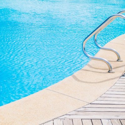 A swimming pool with handles leading down to it.