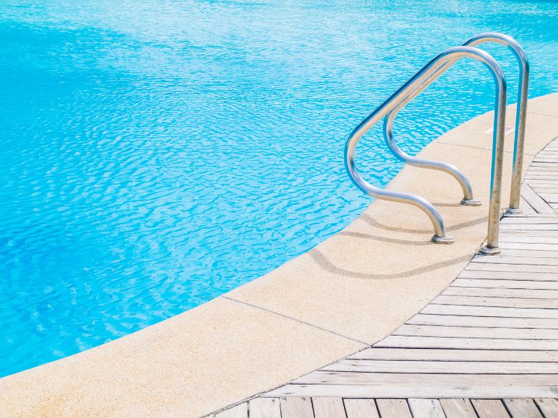 Image of swimming pool with handles leading down to it.