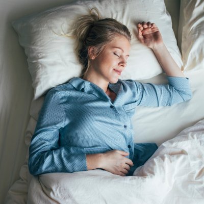 A woman sleeping peacefully on her bed.