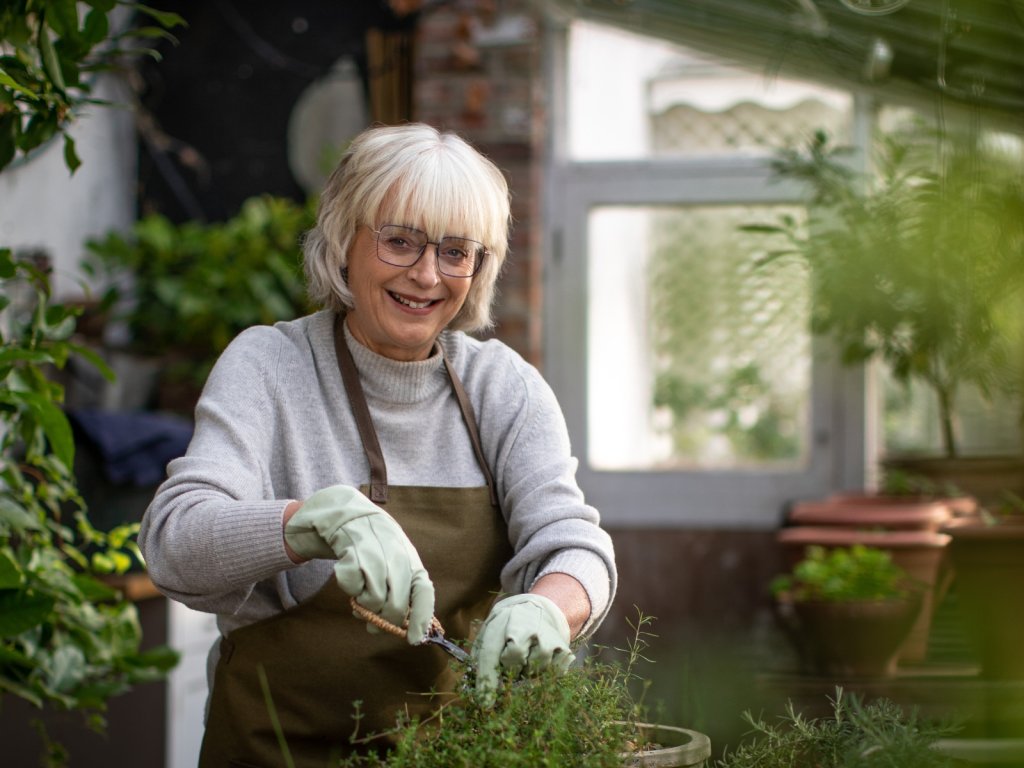 A woman is gardening in a greenhouse.