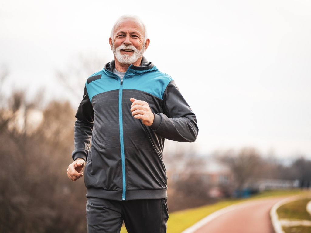 An older man jogging in the park.