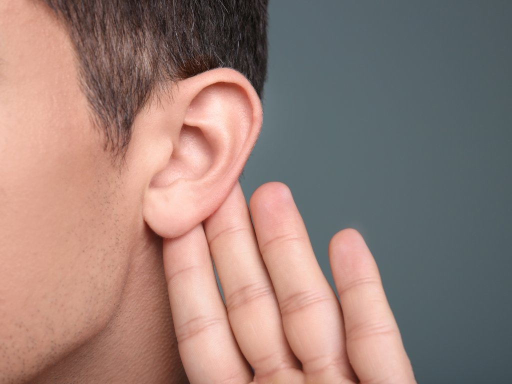 A man holding his ear to listen.