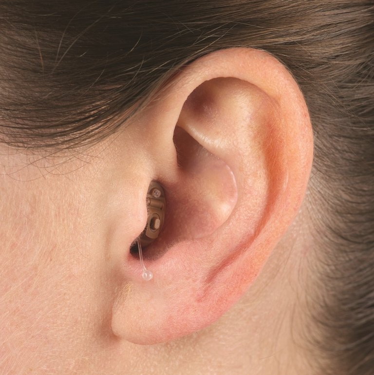 Close-up on a person's ear wearing a completely-in-canal (CIC) hearing aid.