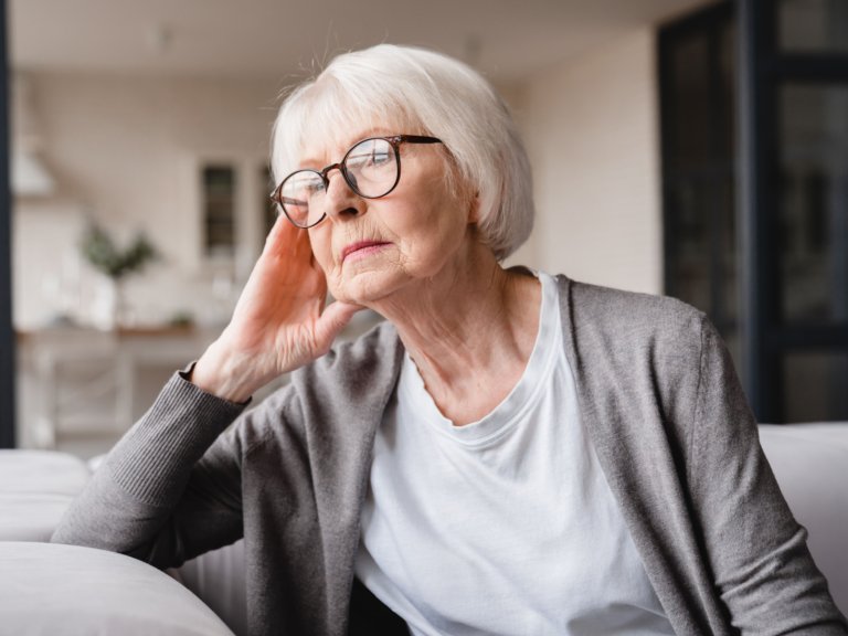 A woman sitting on her sofa looking outside.