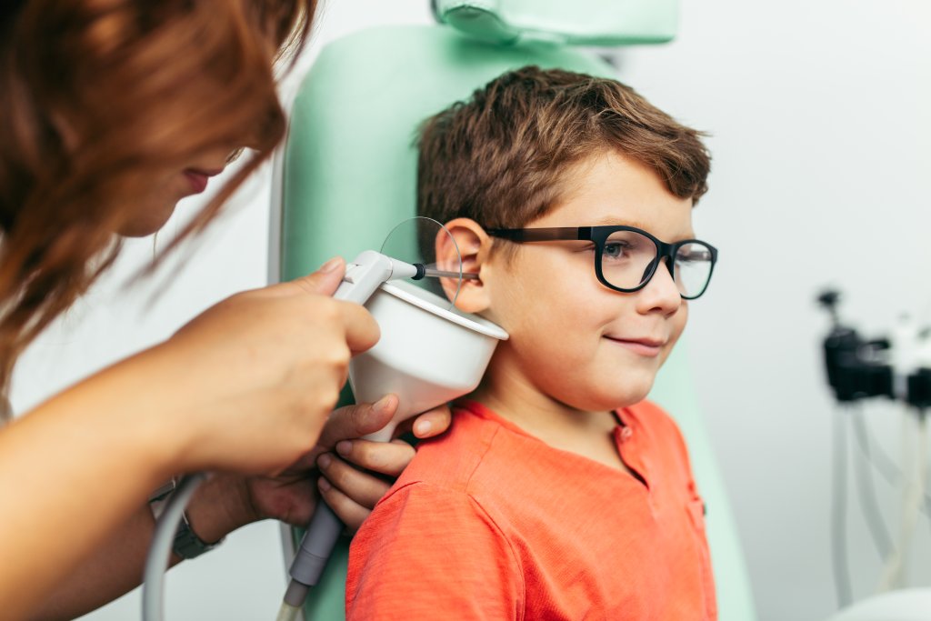 A child having an ear wax removal with a wax clinician.