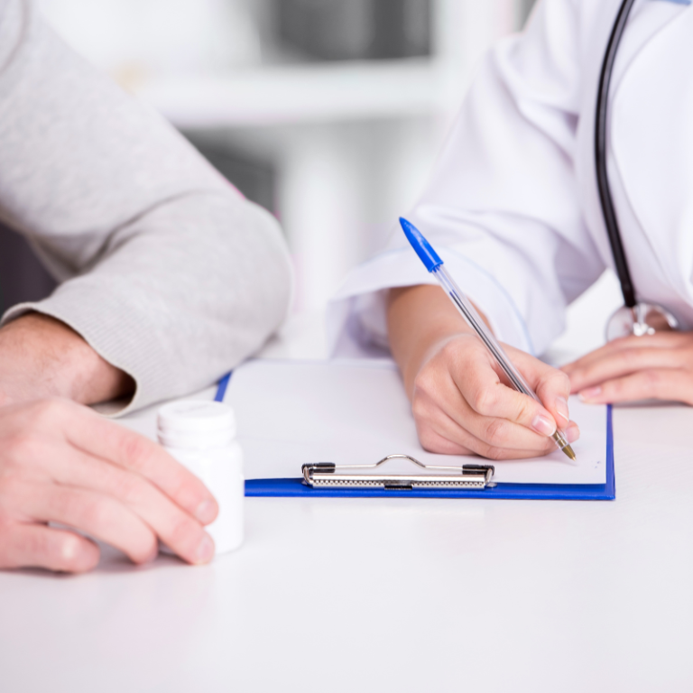 Young doctor writing on a clipboard while a patient holds medication.