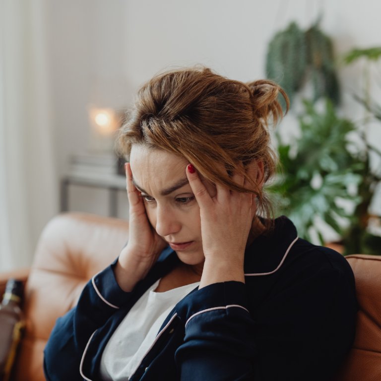 Woman Wearing a Pajama Holding Her Head.