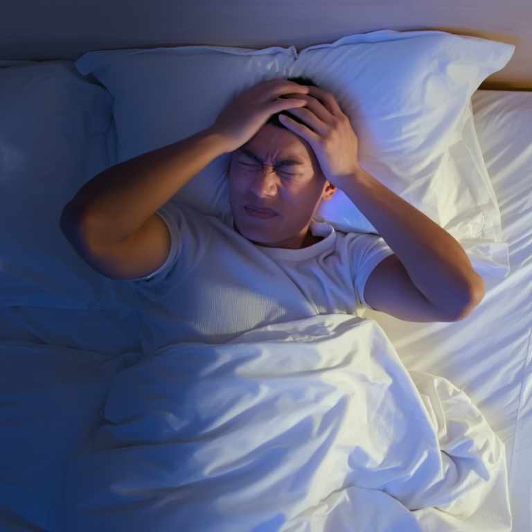 Man with Headache Lying on the Bed.