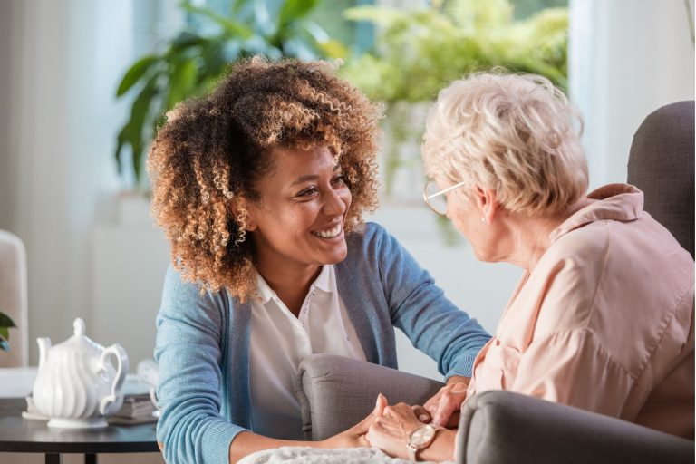 A home caregiver providing compassionate care to an elderly woman, assisting with daily needs and offering support in a warm and nurturing environment.
