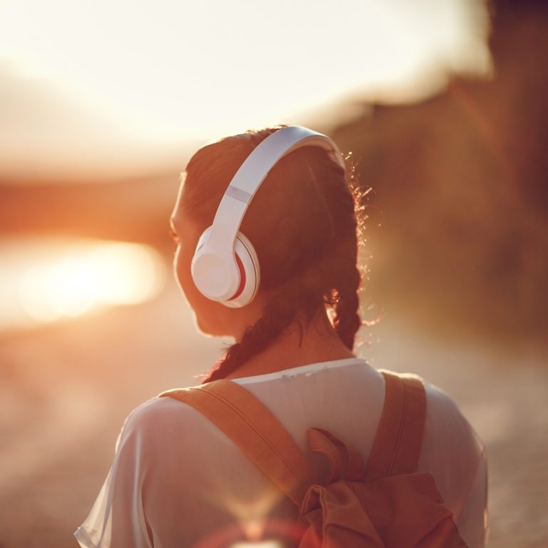 A woman seen from behind, listening to music.