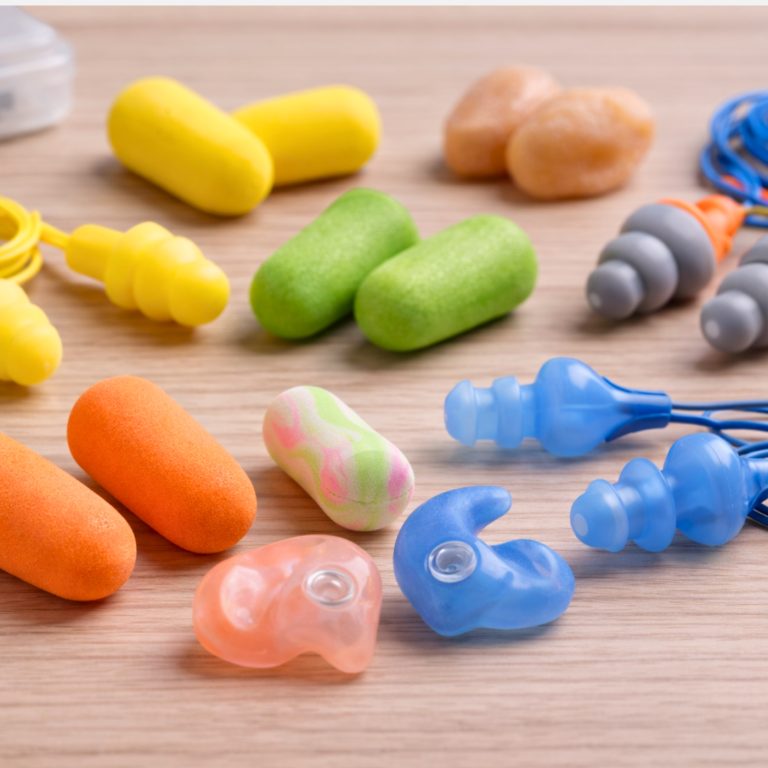 Assorted earplugs on wooden surface.