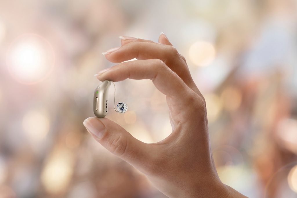 Hand holding a hearing aid.