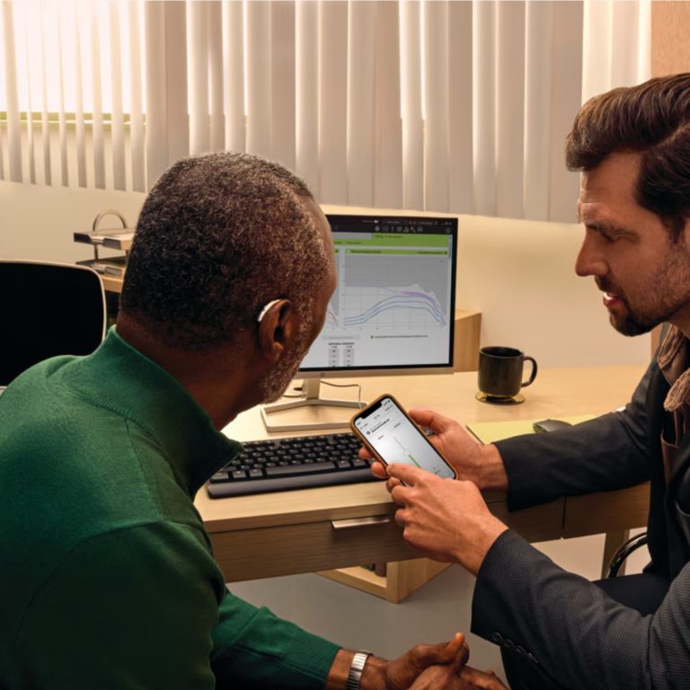 An audiologist showing the Phonak App to a patient.